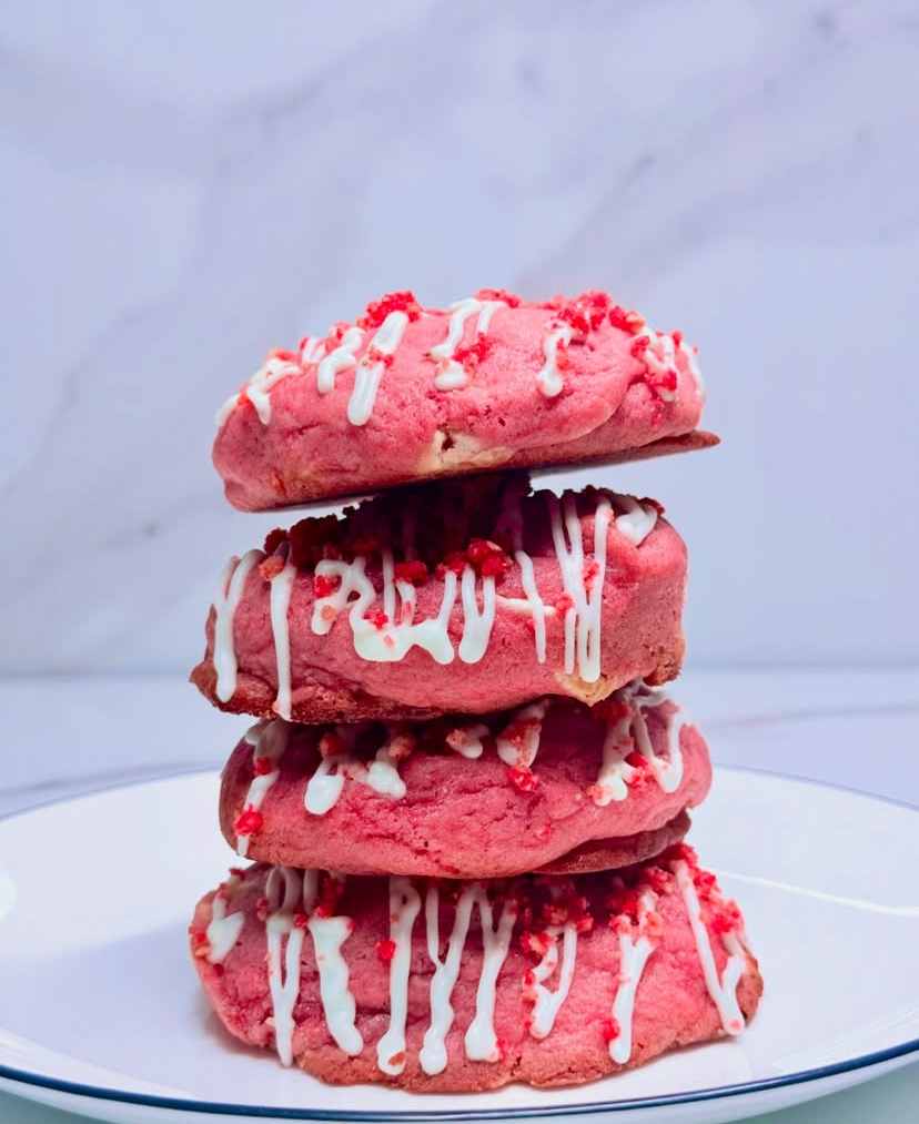 Stack of strawberry crunch cookies with white icing and strawberry crumble