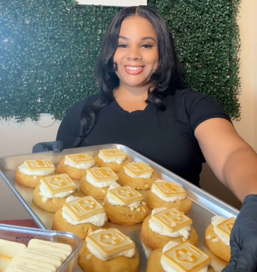 The owner and baker of Blessed Batch holding a fresh tray of cookies